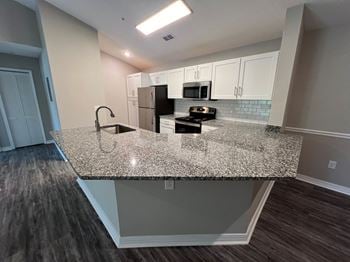 A kitchen with a granite counter top and a sink